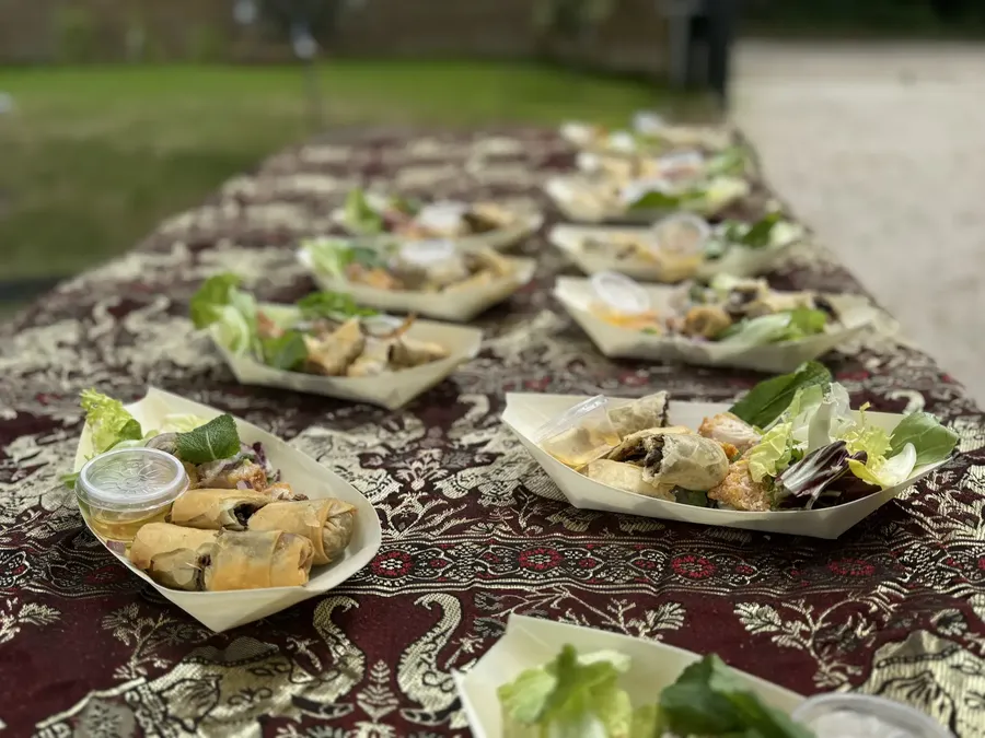 Bouchées thaïes en barquettes dressées sur un buffet traiteur en extérieur