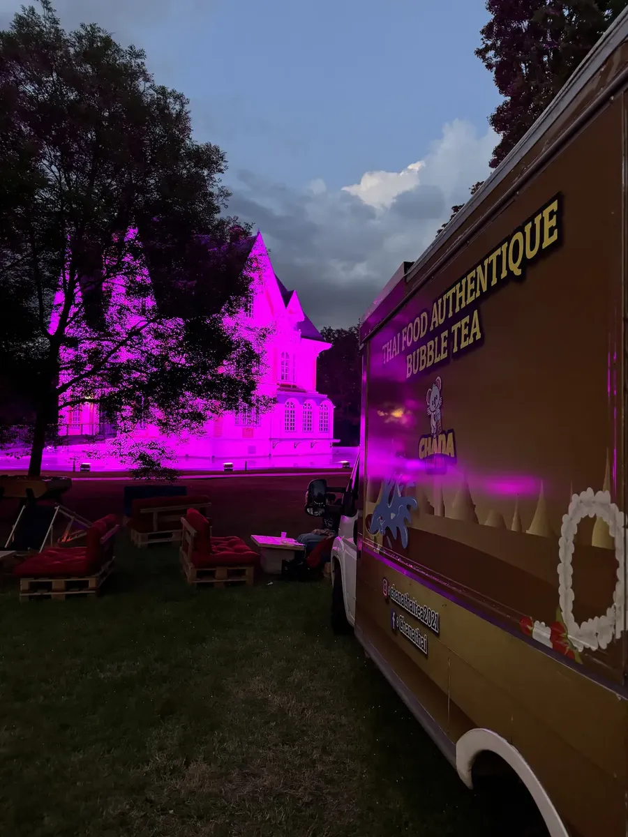 Le food truck Chana Thai éclairé à la tombée de la nuit dans le parc d'une propriété privée
