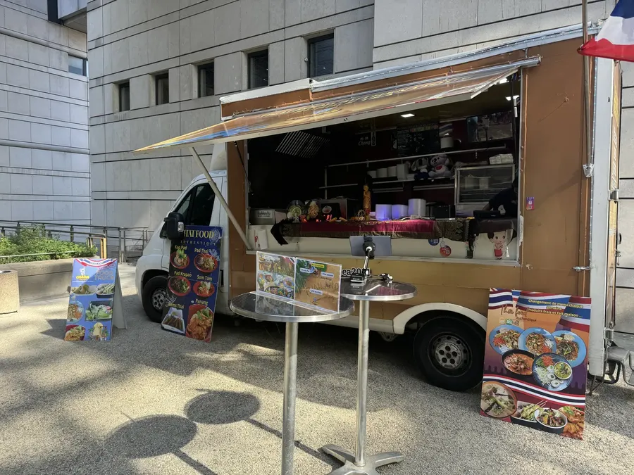 Le food truck Chana Thai installé au pied d'un immeuble de bureaux, drapeau thaï déployé
