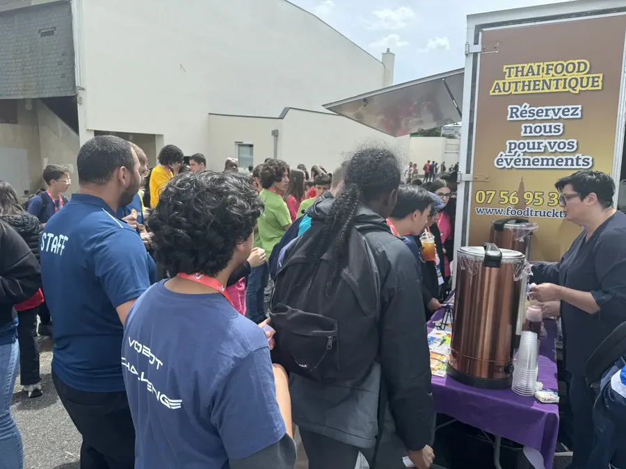 Visiteurs badgés faisant la queue devant le stand Chana Thai lors d'un événement professionnel