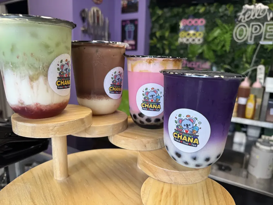 Quatre bubble teas Chana Thai présentés sur des socles en bois