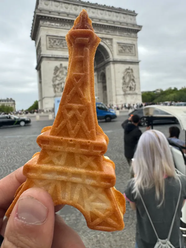 La gaufre mochi tour Eiffel tenue devant l’Arc de Triomphe à Paris