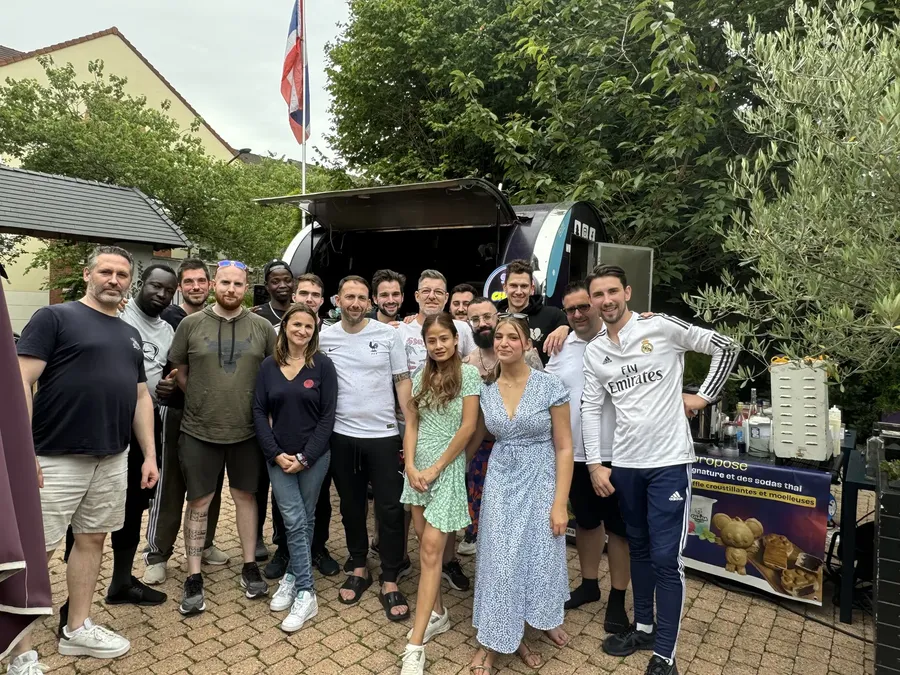 Photo de groupe d'une équipe devant le food truck Chana Thai lors d'un séminaire