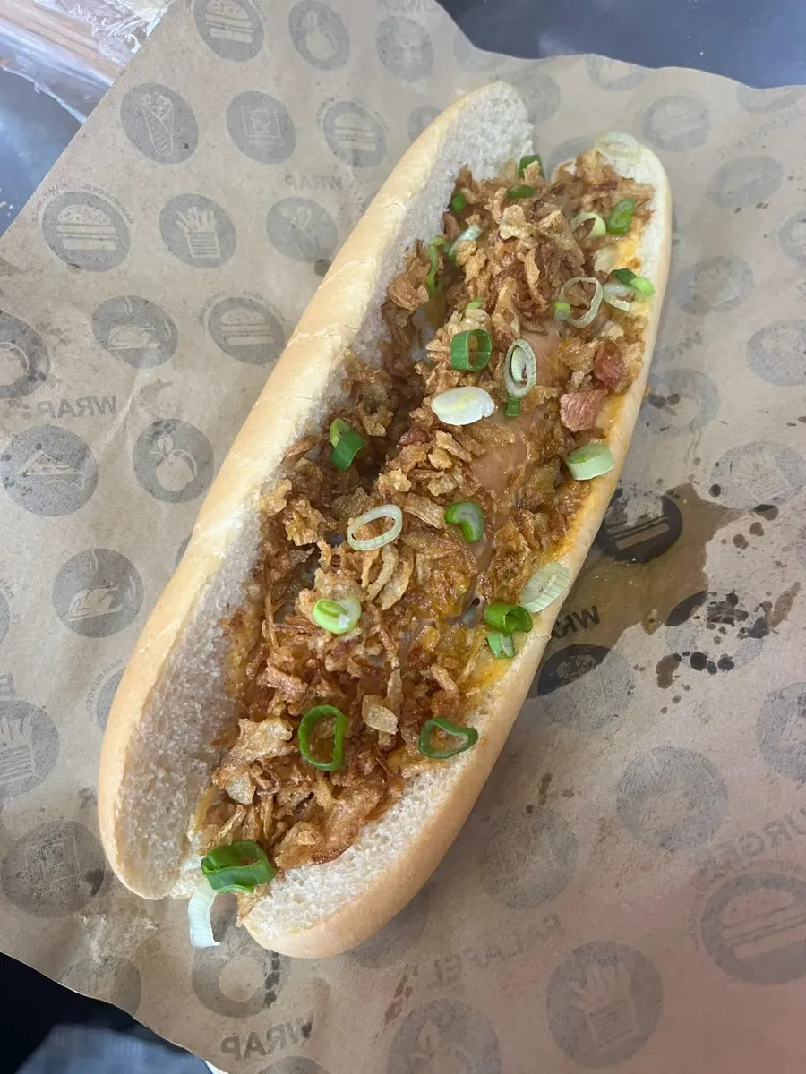 Hot dog crousty thaï garni d’oignons frits, de ciboule et de sauce spicy mayo
