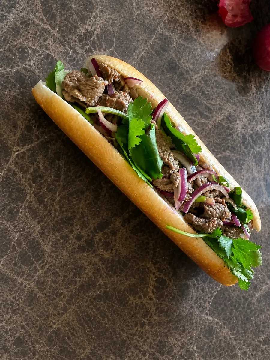 Sandwich thaï laab au bœuf mariné, coriandre fraîche et oignon rouge