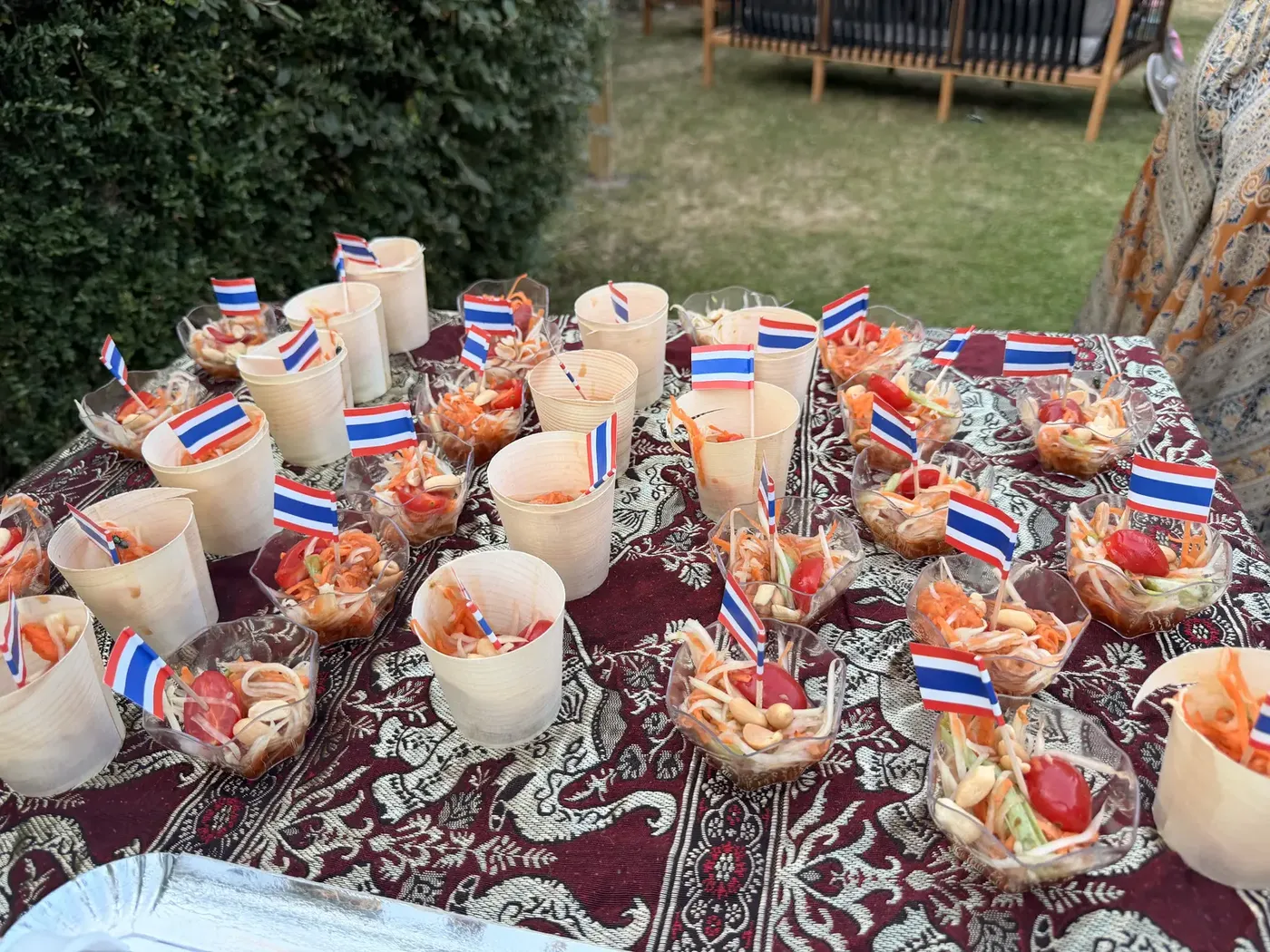 Table de cocktail dressée par Chana Thai : verrines et cônes garnis piqués de drapeaux thaïs